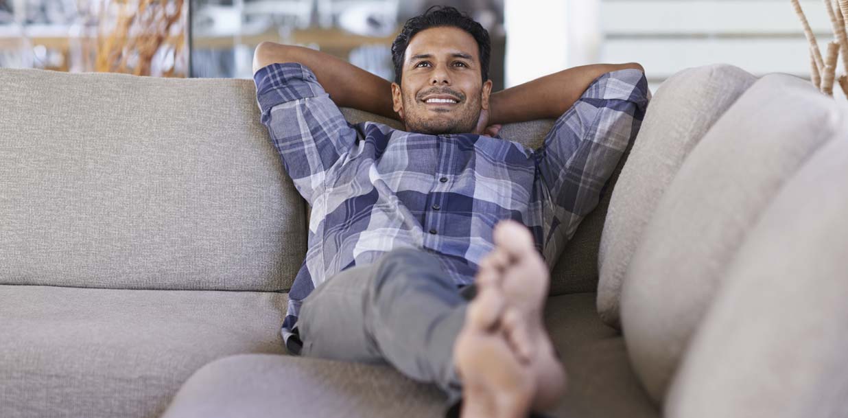 young ethnic man relaxing indoors on his couch