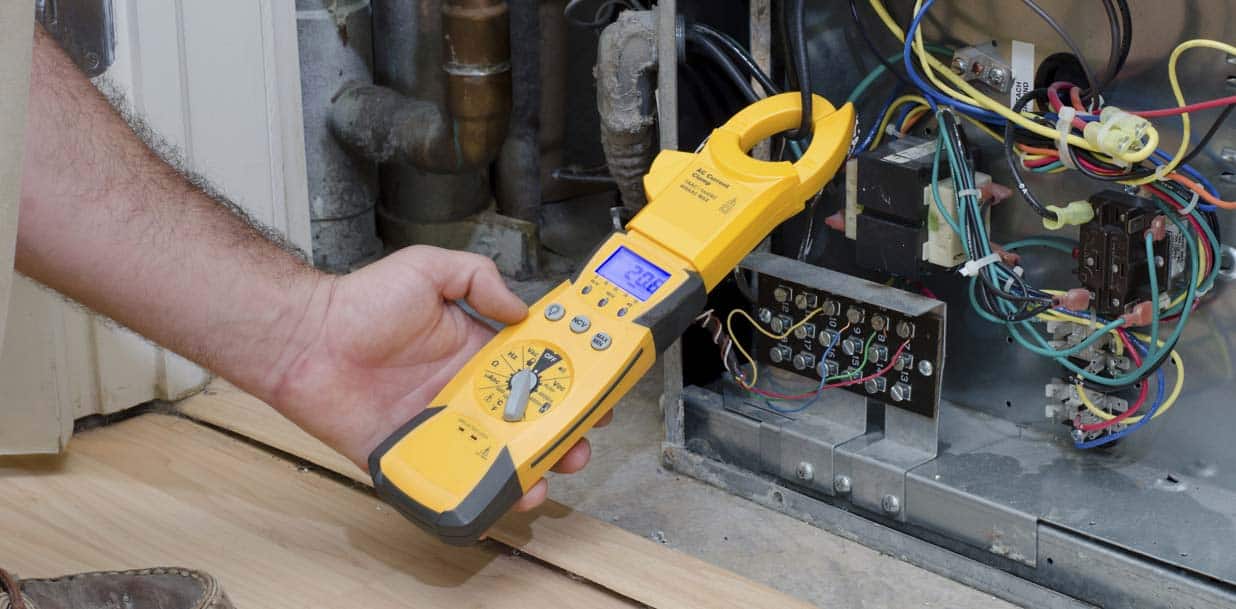 Technician testing a supply cable to an air condition.