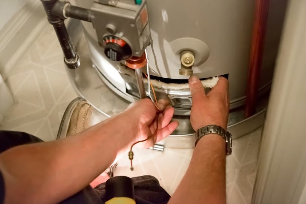 Hands repairing a water heater, focusing on the temperature control valve and insulation, illustrating emergency water heater repair.